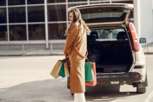 Happy woman on parking lot after shopping.