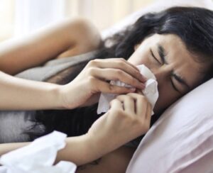 woman sick in bed quarantining.